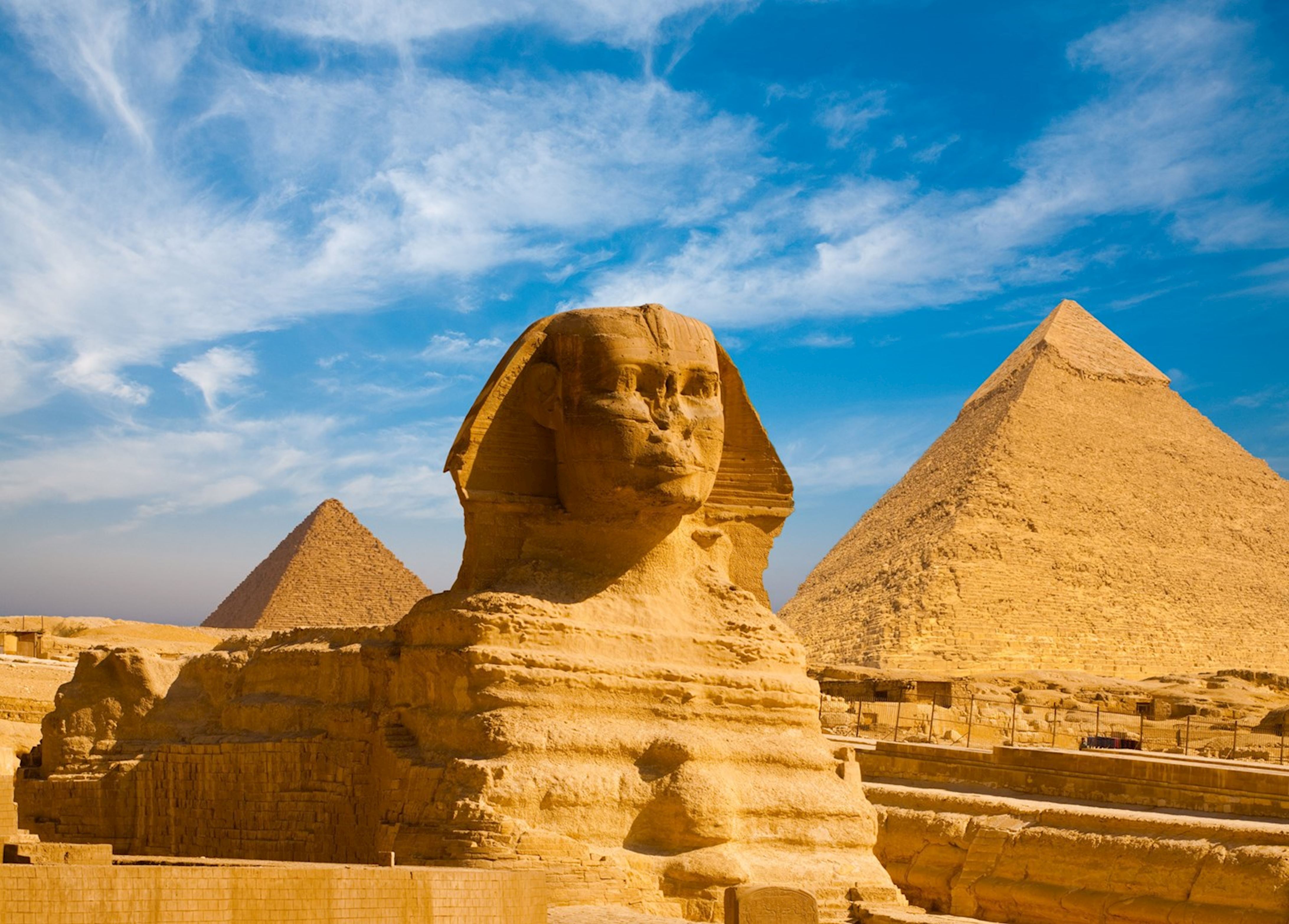 Pyramids of Giza rising from the desert at sunset, Egypt